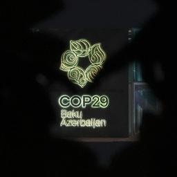 Das Logo des UN-Klimagipfels COP29 ist durch ein Kunstwerk vor dem Veranstaltungsort sichtbar.