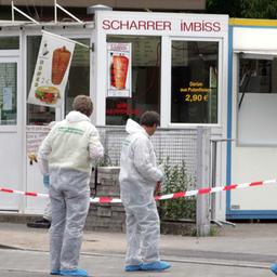 Polizisten der Spurensicherung in weißen Schutzanzügen arbeiten an einem Imbiss in Nürnberg, dessen Besitzer im Juni 2005 erschossen wurde.