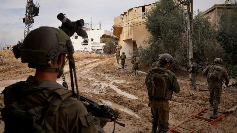 Israelische Soldaten laufen bei der Bodenoffensive durch einen Ort im Gazastreifen