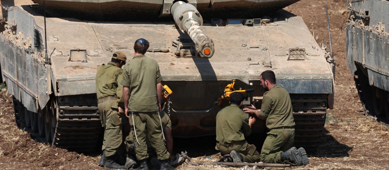 Israelische Soldaten kontrollieren Militärfahrzeuge an einem Sammelplatz an der Grenze zum Libanon.