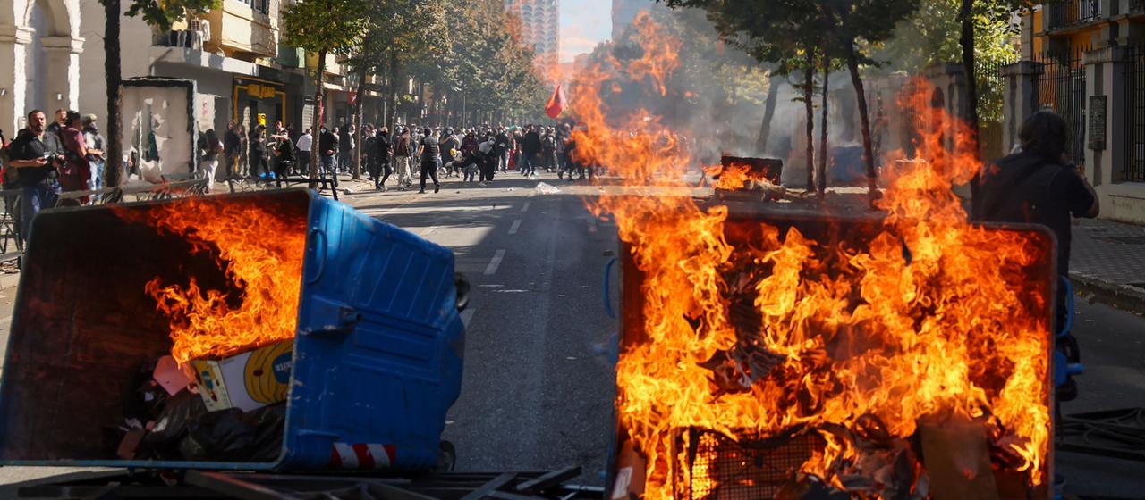 Mülltonnen brennen auf einer Straße der albanischen Hauptstadt Tirana.