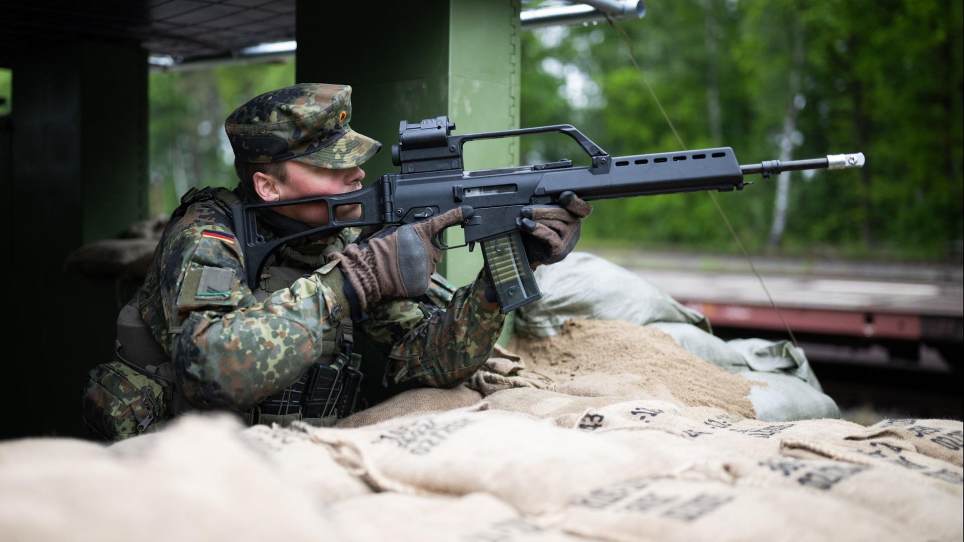 Ein Heimatschützer der Heimatschutzdivision sichert in Bergen (Niedersachsen) während einer Übung am Truppenübungsplatz die Bahnentladung von Kettenfahrzeugen der Panzergrenadierbrigade 37. | Julian Stratenschulte/dpa