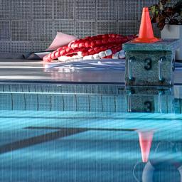 Symbolbild: Gesperrte Schwimmhalle in Berlin - Auf einem Startblock steht ein Warnkegel. (Quelle: dpa/Pedersen)