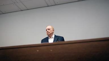 Alfons Schuhbeck steht im Gerichtssaal