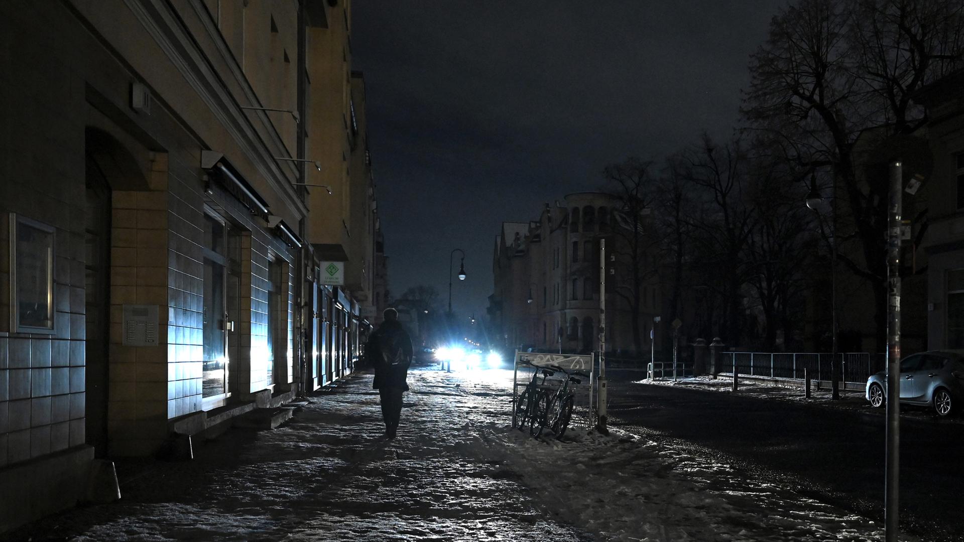 Eine Person läuft eine dunkle Straße in Berlin Zehlendorf entlang. | dpa