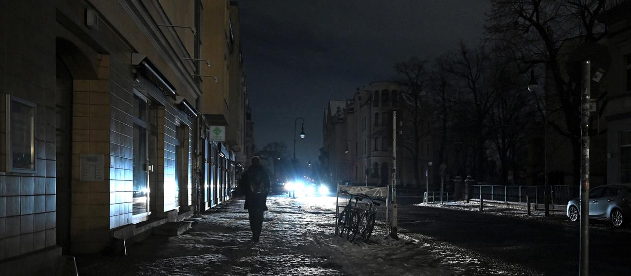 Eine Person läuft eine dunkle Straße in Berlin Zehlendorf entlang.