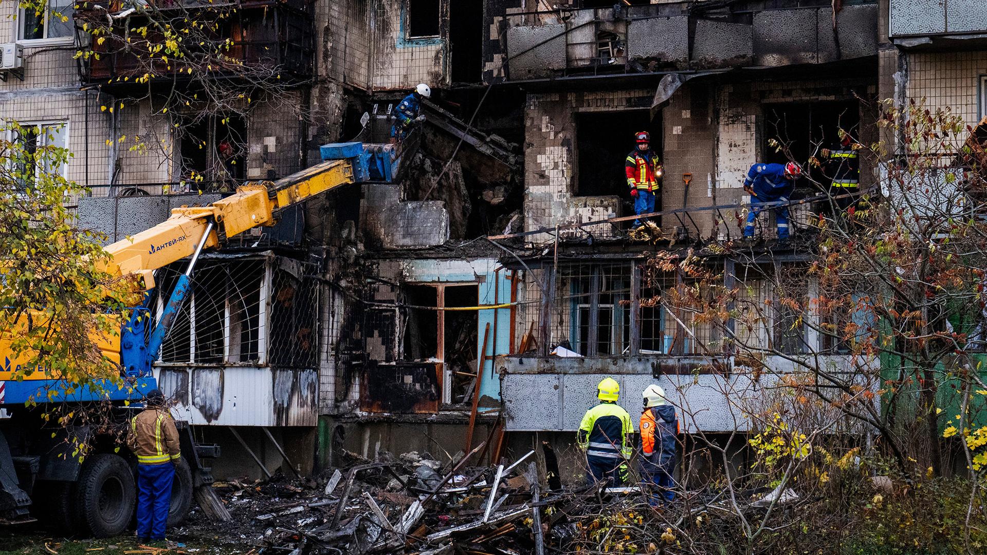 Mehrere RettungskrÀfte arbeiten an einem stark beschÀdigten Wohnhaus in Kiew. | AP