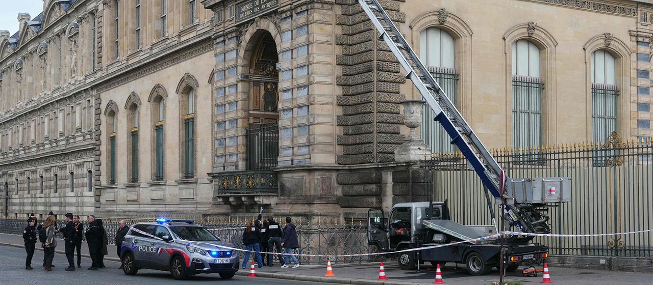 Polizisten stehen neben einem Möbelaufzug, mit dem Einbrecher in das Louvre-Museum eindrangen. | AFP Polizisten stehen neben einem Möbelaufzug, mit dem Einbrecher in das Louvre-Museum eindrangen.