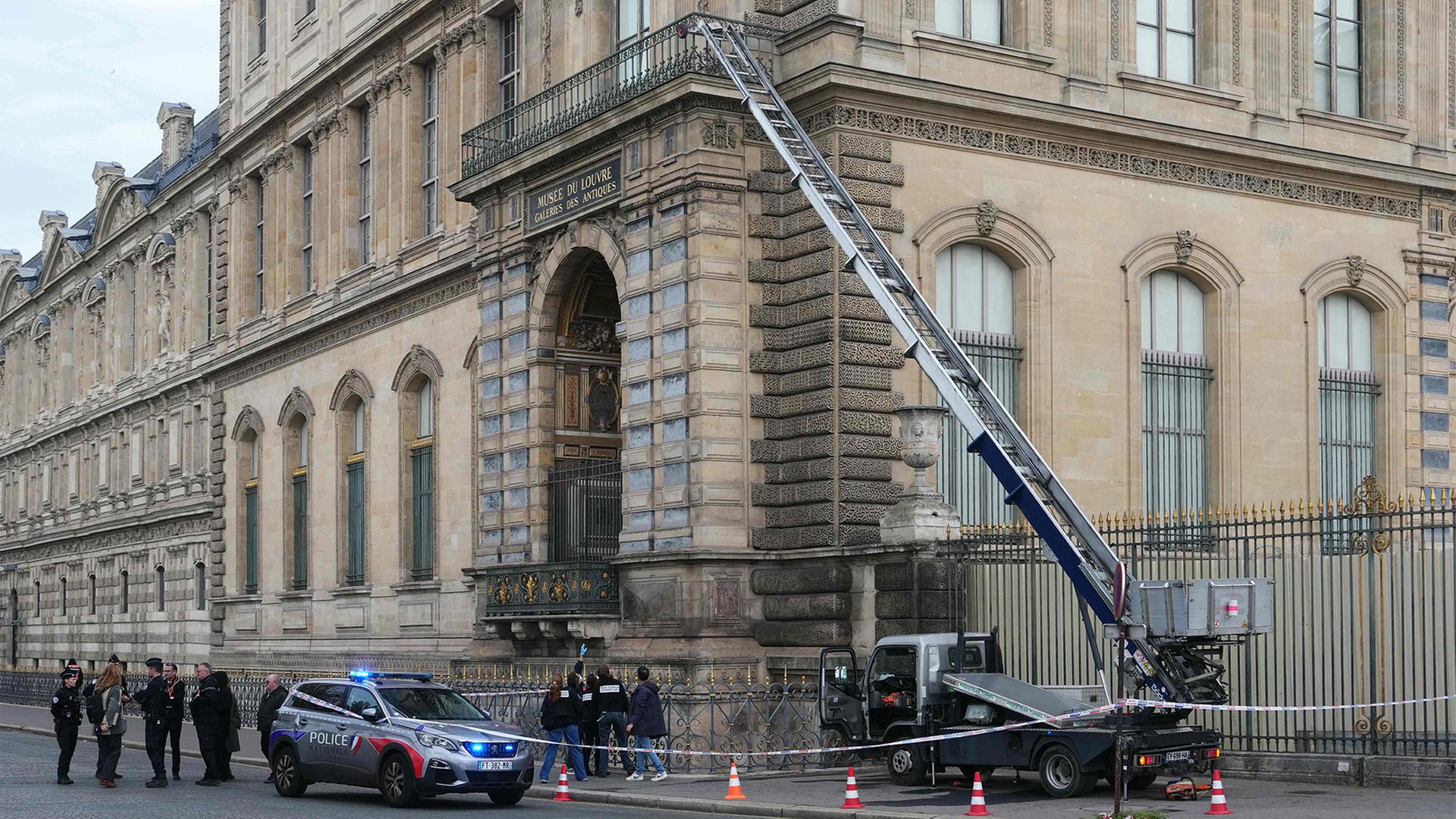 Polizisten stehen neben einem Möbelaufzug, mit dem Einbrecher in das Louvre-Museum eindrangen.  | AFP