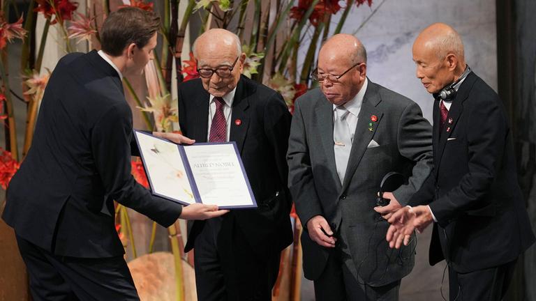 Jorgen Watne Frydnes überreicht die Urkunde des Friedensnobelpreises an Terumi Tanaka, Shigemitsu Tanaka und Toshiyuki Mimaki.