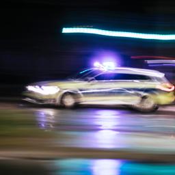Ein Streifenwagen fährt bei Dunkelheit mit eingeschaltetem Blaulicht.