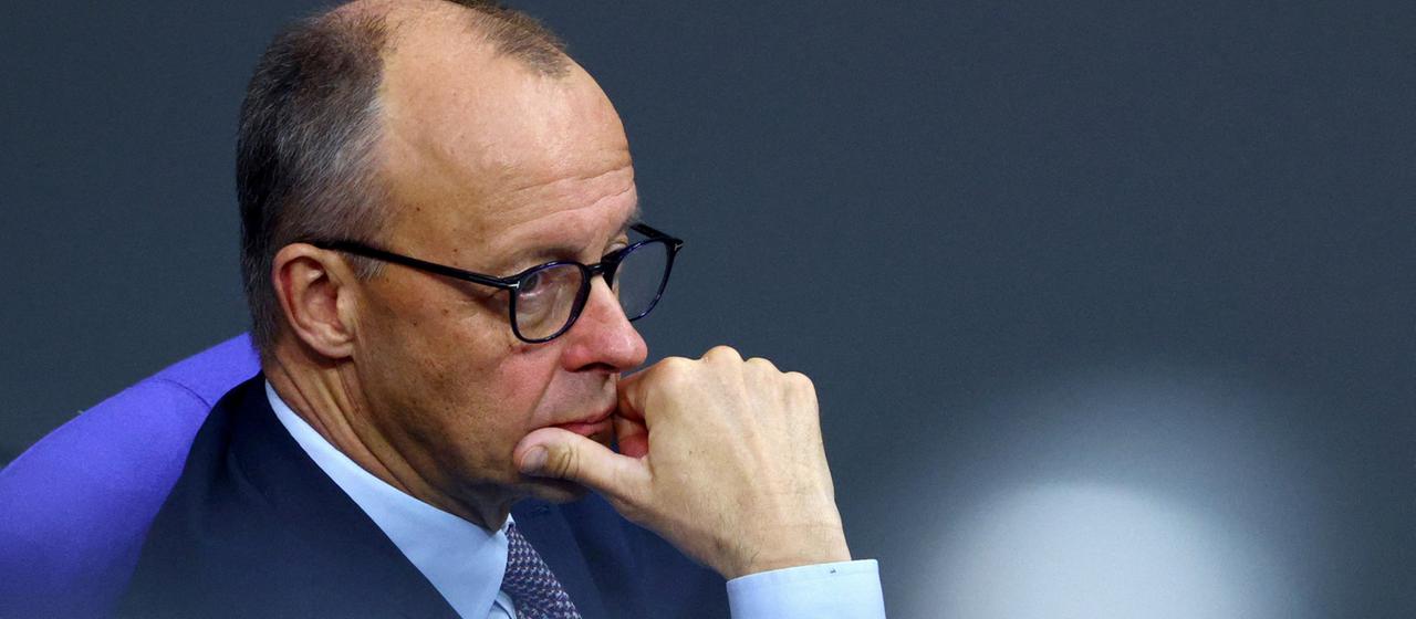 Friedrich Merz stützt das Kinn auf die rechte Hand. | REUTERS Friedrich Merz stützt das Kinn auf die rechte Hand.