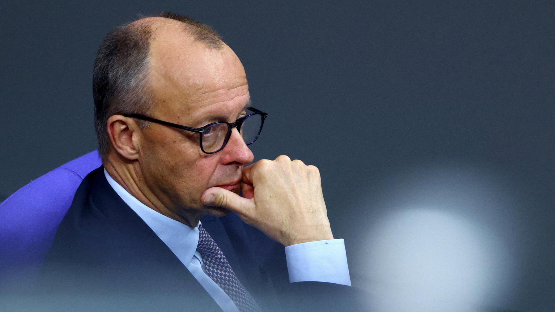 Friedrich Merz stützt das Kinn auf die rechte Hand. | REUTERS