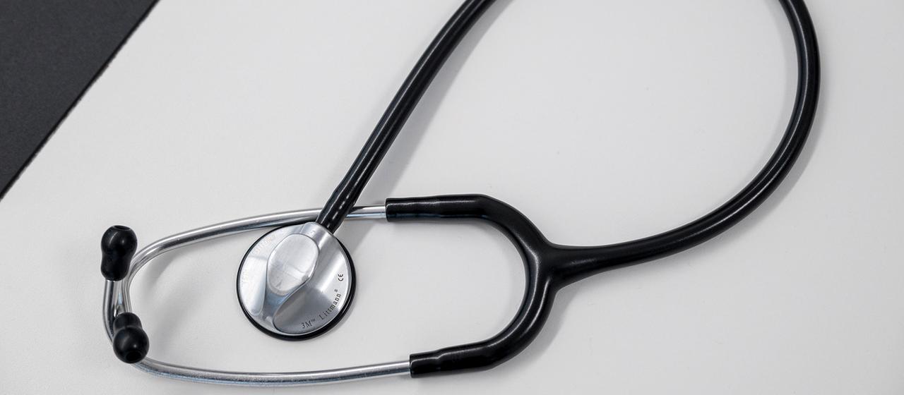 Ein Stethoskop liegt auf einem Tisch.