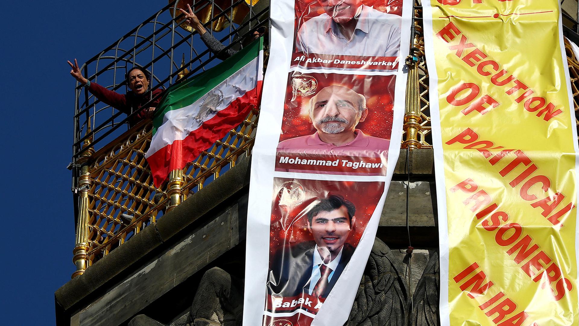 Menschen entrollen auf der Siegessäule in Berlin ein Transparent mit der Aufschrift 