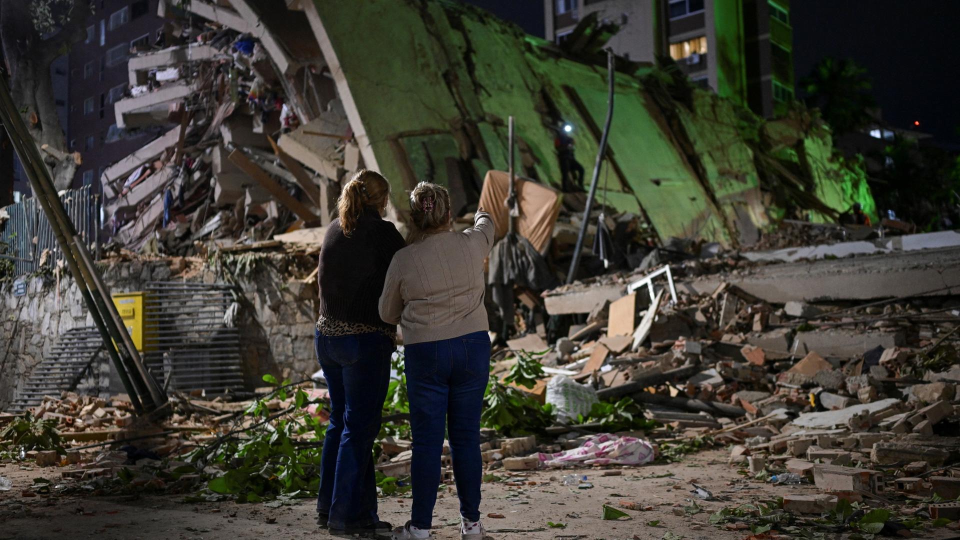 Zwei Frauen stehen nach den schweren Erdbeben vor einem Tr�mmerfeld in Caracas, Venezuelae | REUTERS