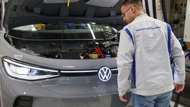 Ein Mitarbeiter kontrolliert einen ID.4 im Werk von Volkswagen in Zwickau.