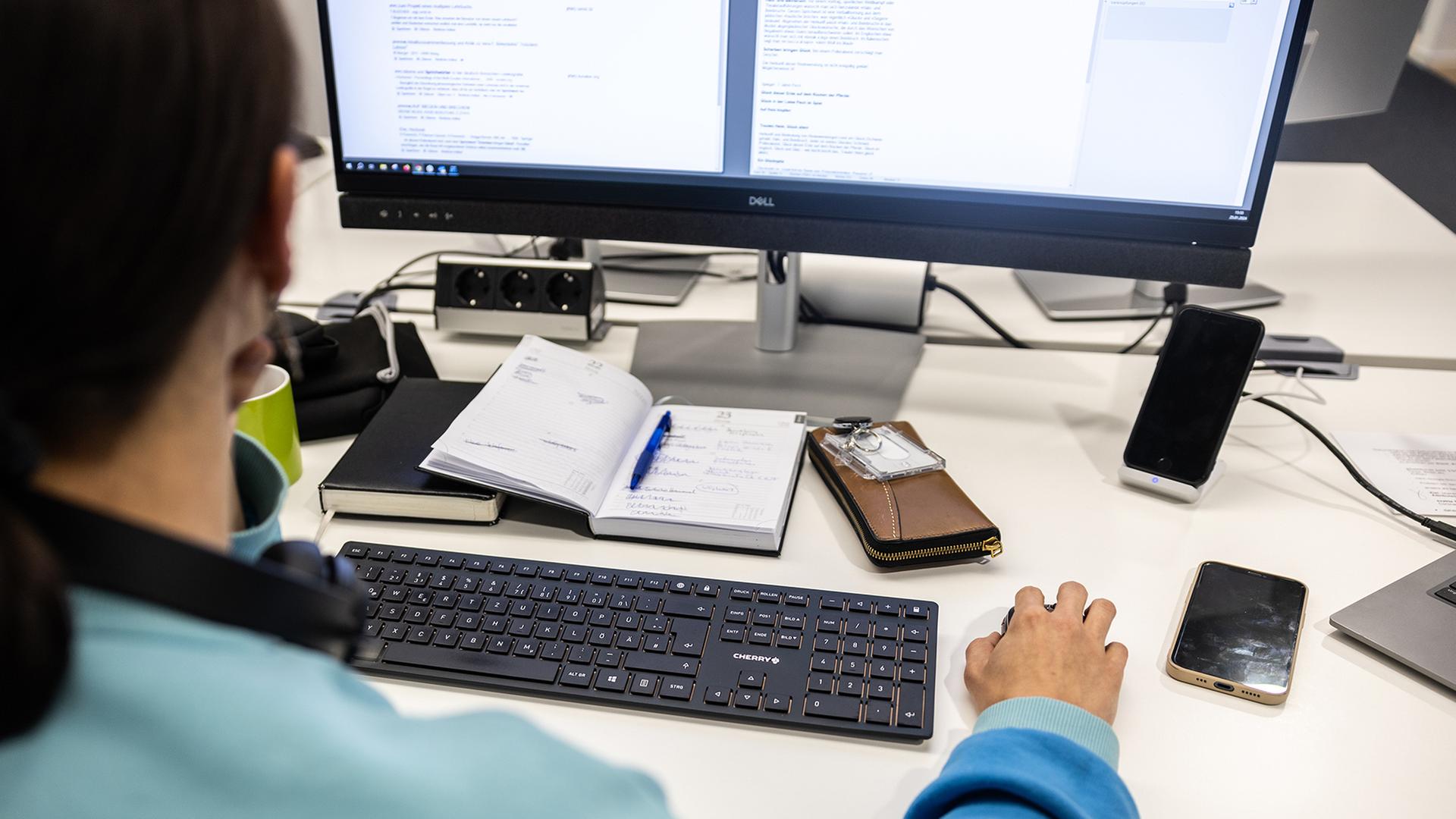 Eine Frau sitzt am Schreibtisch und arbeitet am Computer. | dpa
