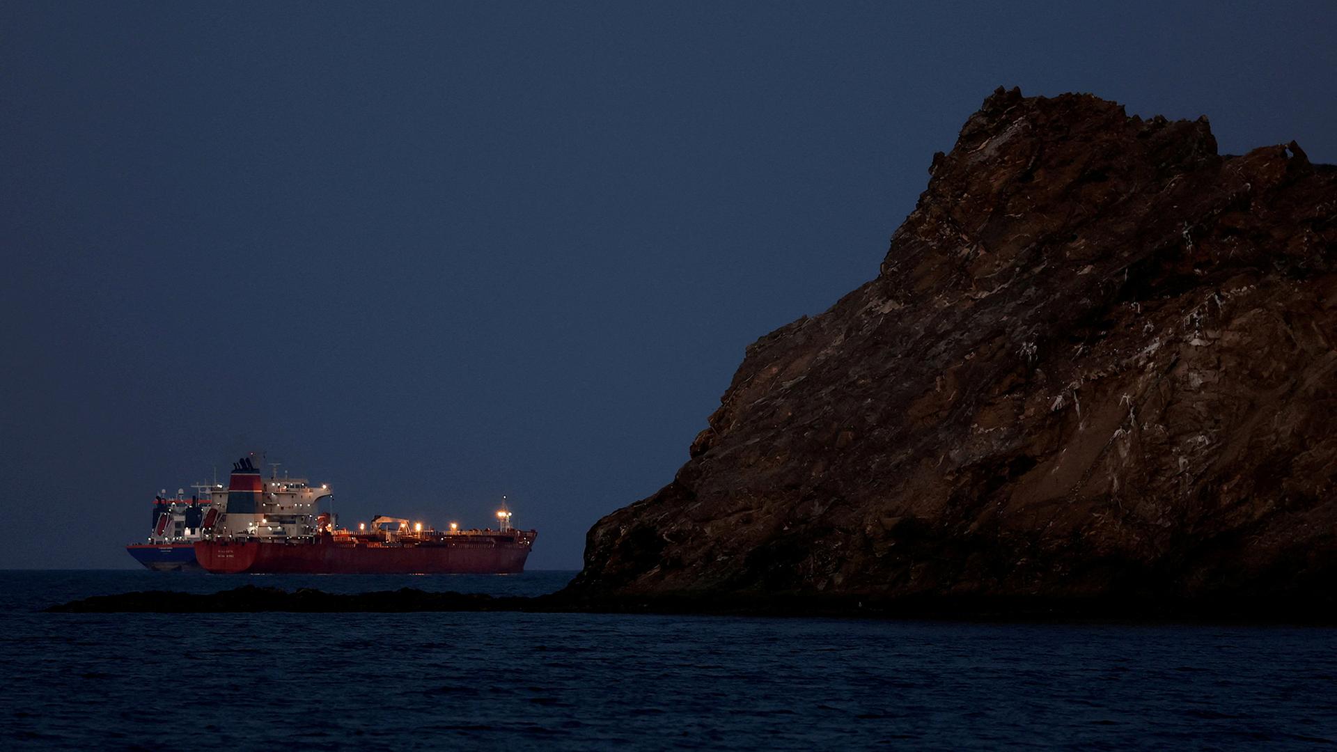 Ein beleuchteter �ltanker ankert vor einem Felsen. | REUTERS