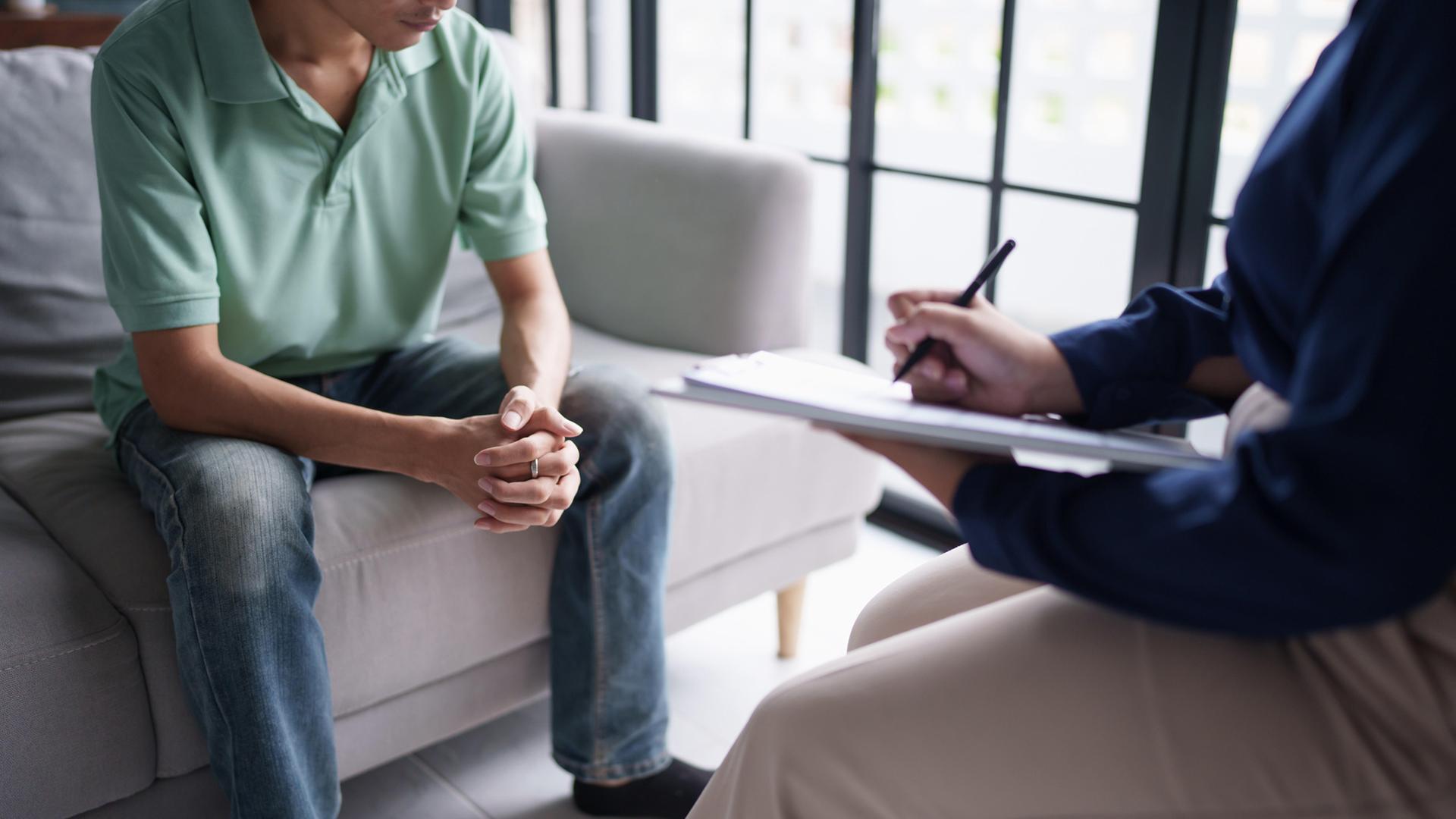 Ein Psychotherapeut macht Notizen bei einer Sitzung mit einem Patienten. | picture alliance / Zoonar