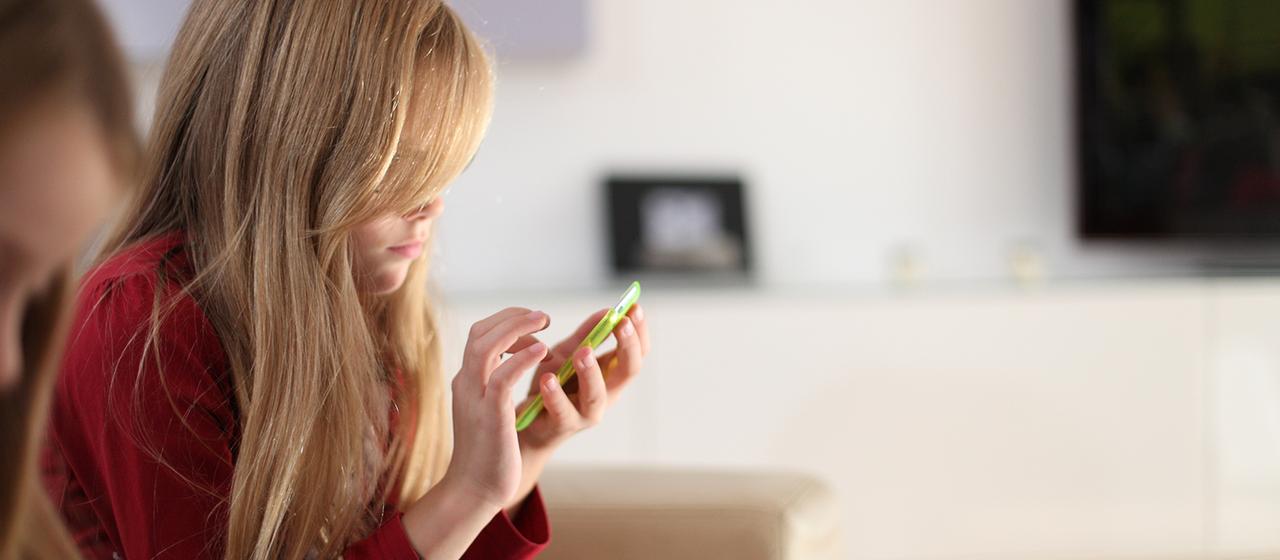 Ein Mädchen hält ein Handy in ihren Händen.