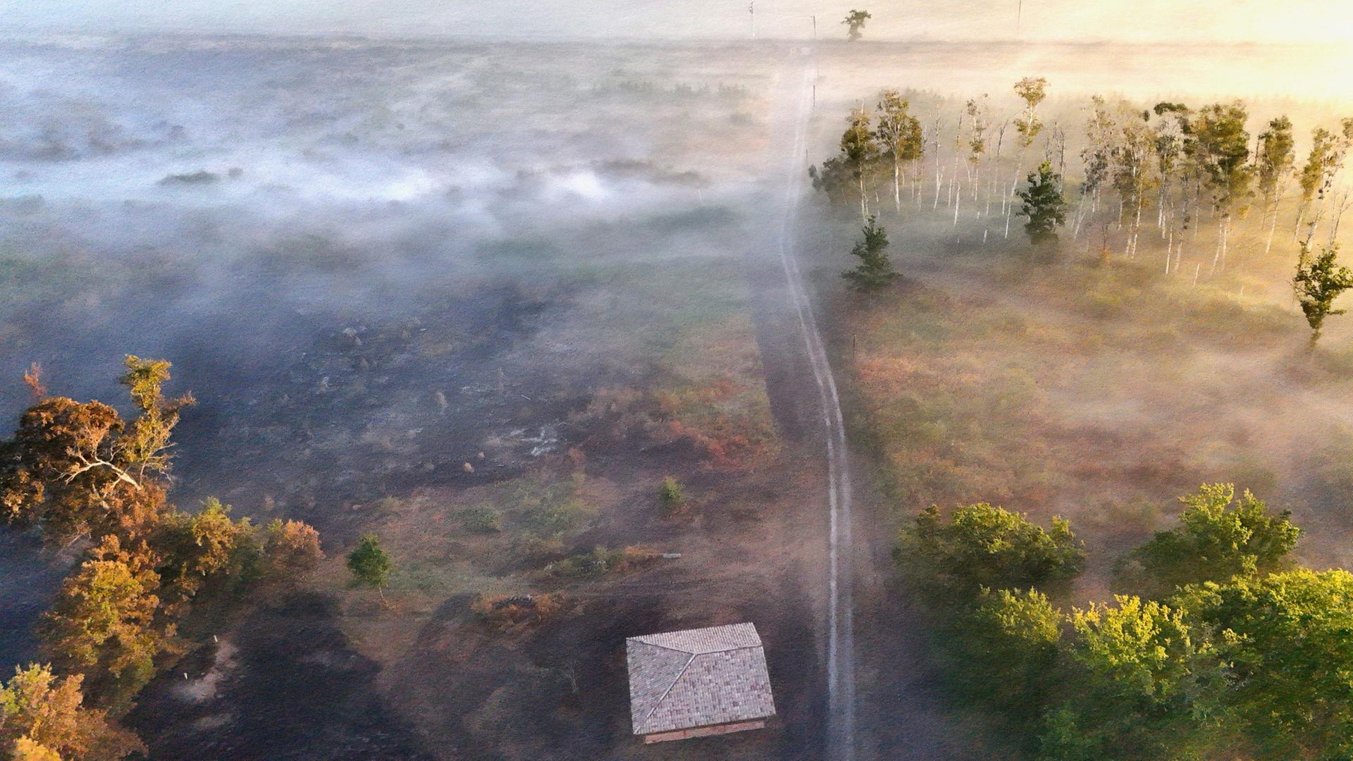 Eine Drohnenaufnahme zeigt Rauch und Nebel über einem durch einen Waldbrand in der Nähe von Saumos in Frankreich geschädigten Waldgebiet. | REUTERS