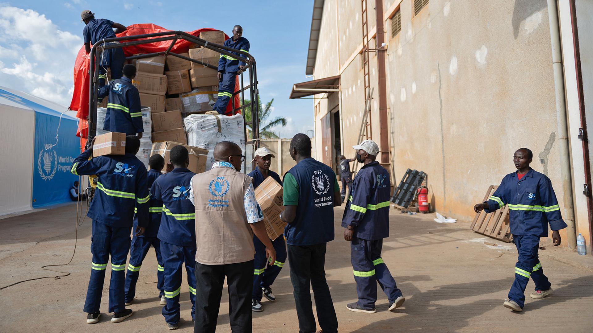 Menschen laden im Lager des Welternährungsprogramms in Bunia, DR Kongo, Vorräte von einem Lkw ab | AP Photo/Moses Sawasawa