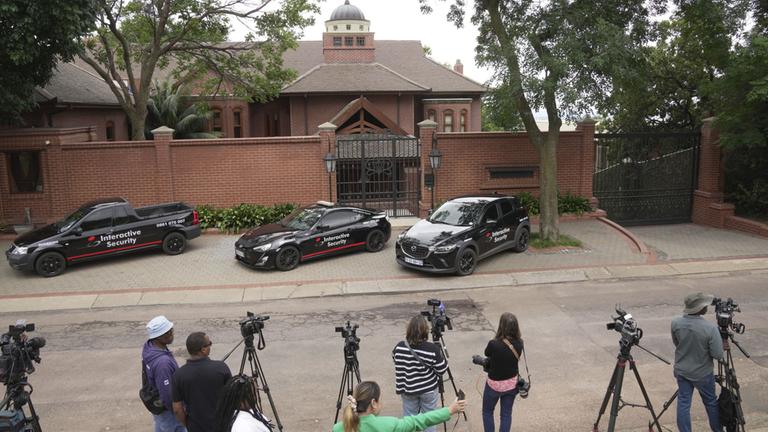 Reporter und Fahrzeuge eines privaten Sicherheitsdienstes stehen vor dem Anwesen von Pistoius' Onkel in Pretoria.