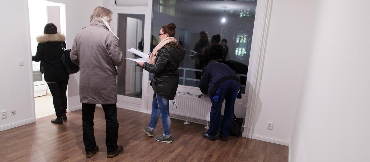 Interessenten besichtigen eine freie Wohnung.