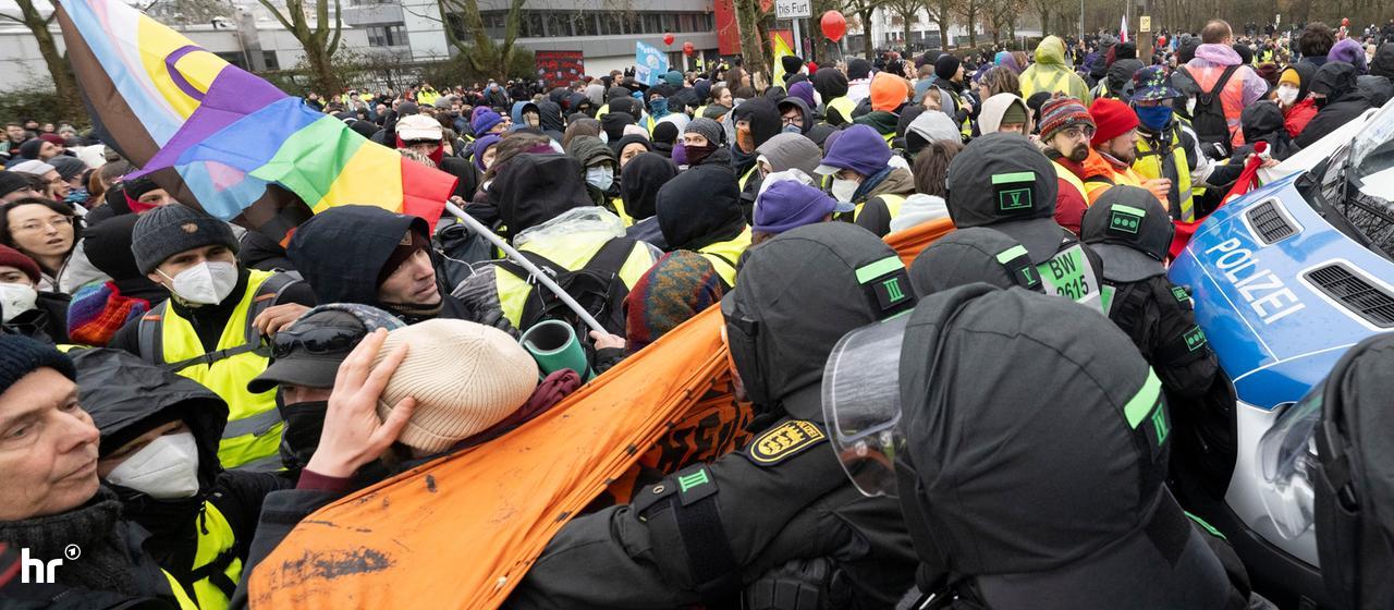 Eine Gruppe Protestierender wird von der Polizei zusammengeschoben