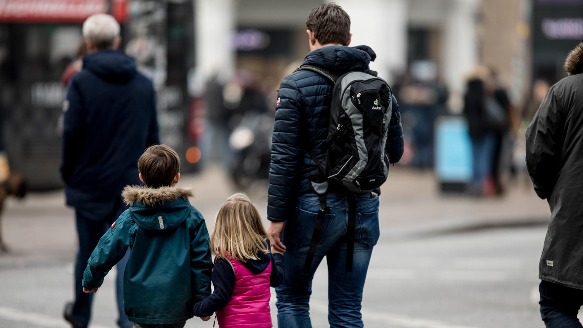 Ein Vater geht mit seinen Kinder �ber eine Stra�e. | ARD-aktuell / Weiss