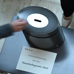 Mitglieder des Deutschen Bundestages geben ihre Stimme an einer Wahlurne ab. 