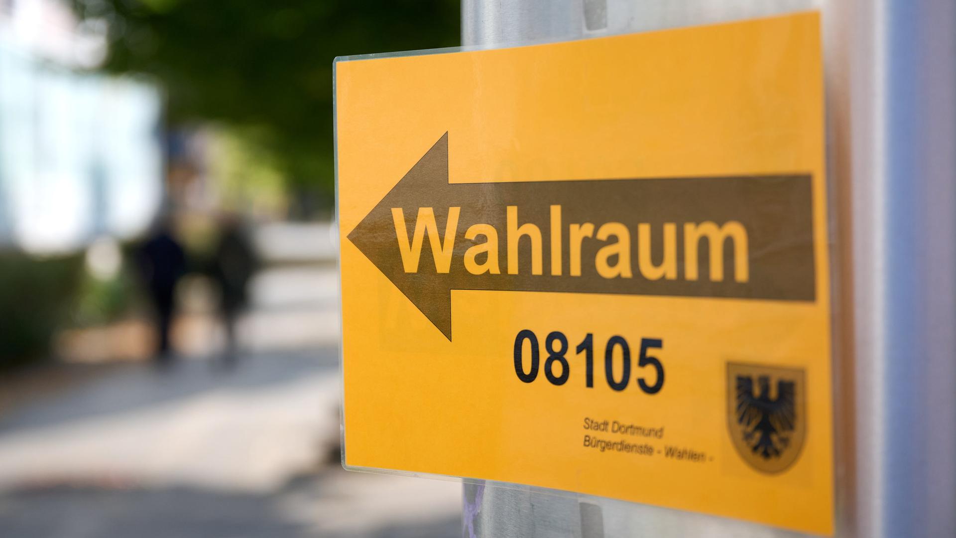 Ein Schild weist den Weg zu einem Wahlraum in Dortmund. | dpa