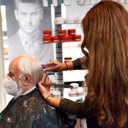 Eine Friseurin schneidet einem Kunden die Haare.