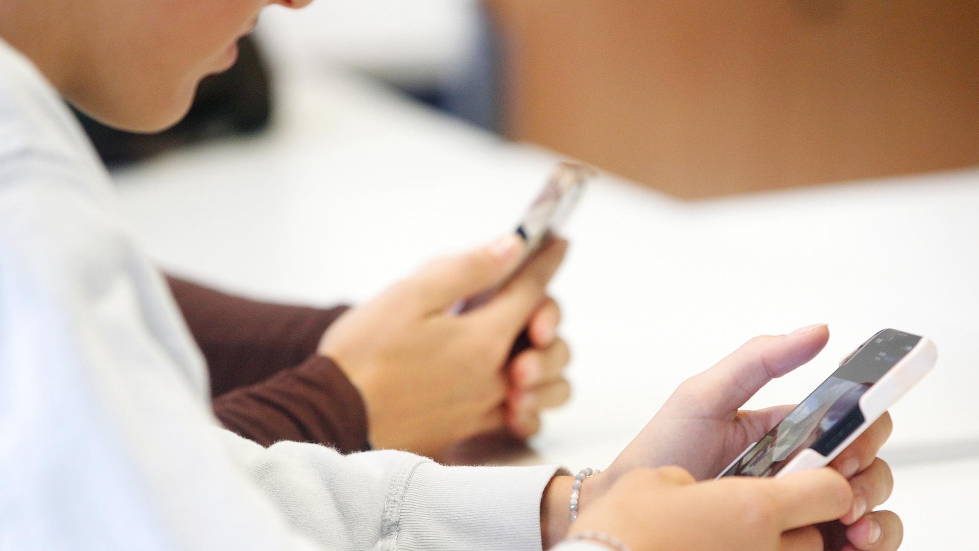 Jugendliche halten Smartphones in den Händen.  | dpa