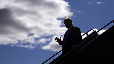 Donald Trump entsteigt einem Flugzeug. 