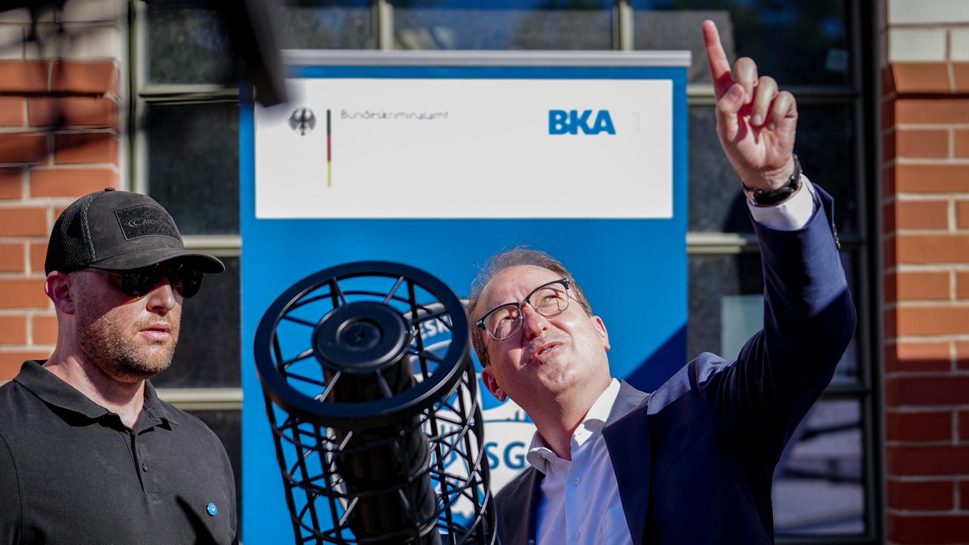 Alexander Dobrindt steht mit Beamten des Bundeskriminalamts an einem Jammergewehr für die Drohnenabwehr. (Archivbild vom 1. Juli 2025) | dpa