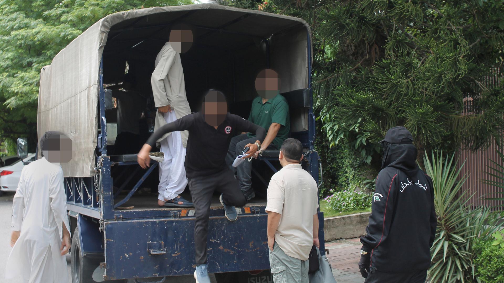 Festgenommene Afghanen aus dem Bundesaufnahmeprogramm in Islamabad sitzen und stehen in einem Transporter. | dpa