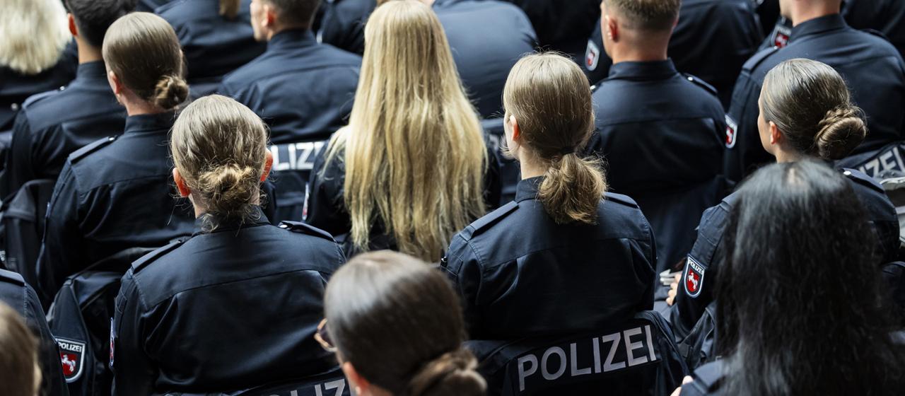Junge Polizisten sitzen in der Polizeiakademie