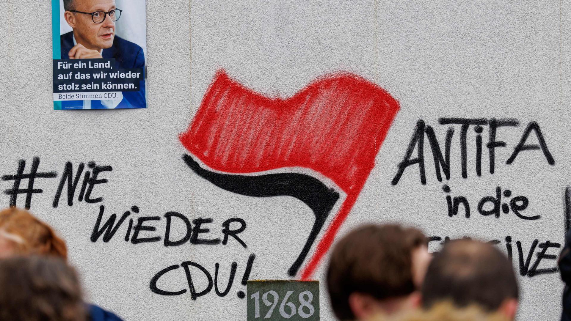 Auf die Wand der Schützenhalle in Menden wurde ein Graffiti gesprüch, mit dem die CDU und Friedrich Merz beleidigt werden | dpa