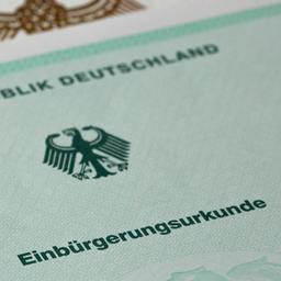 Eine Einbürgerungsurkunde der Bundesrepublik Deutschland liegt auf einem Tisch.