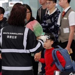 Eine Beamtin der Gesundheitsüberwachung überprüft in der Nähe der Immigrationsschalter die Temperatur von am internationalen Flughafen von Hongkong ankommenden Reisenden.