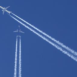 Kondensstreifen zweier Flugzeuge am blauen Himmel