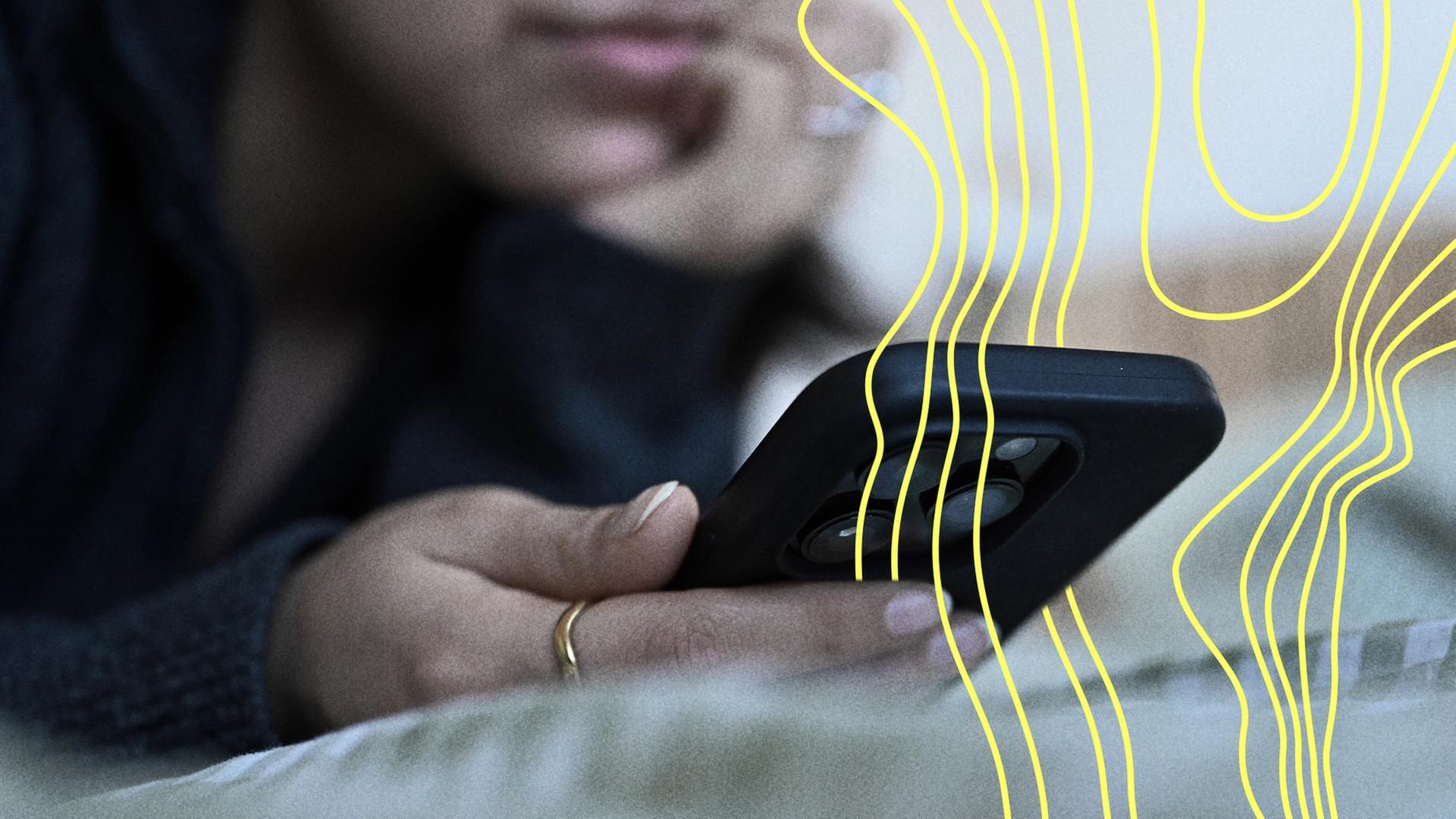 Eine junge Frau liegt mit dem Smartphone in der Hand auf dem Bett. | picture alliance/dpa | Elisa Schu