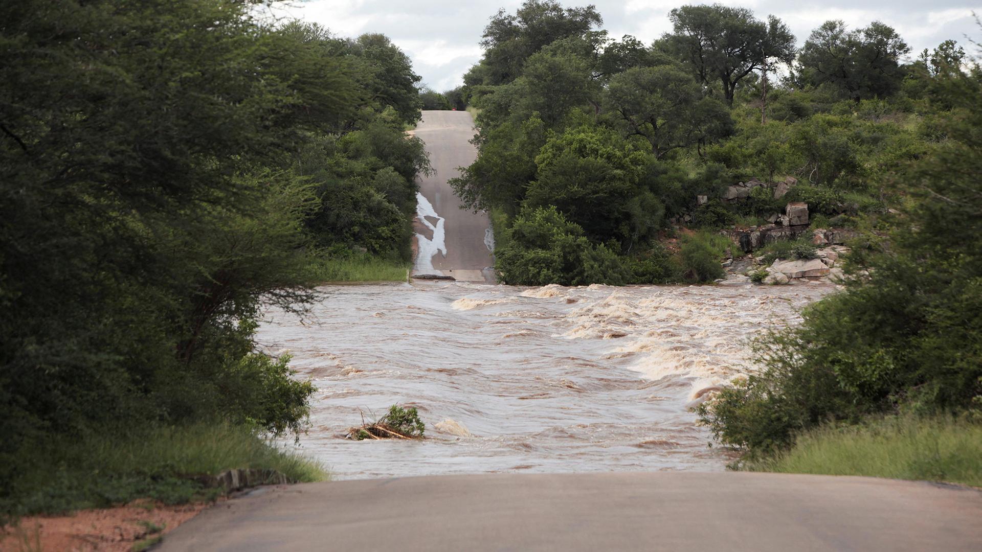 Eine überschwemmte Straße wurde von den Wassermassen beschädigt. | REUTERS
