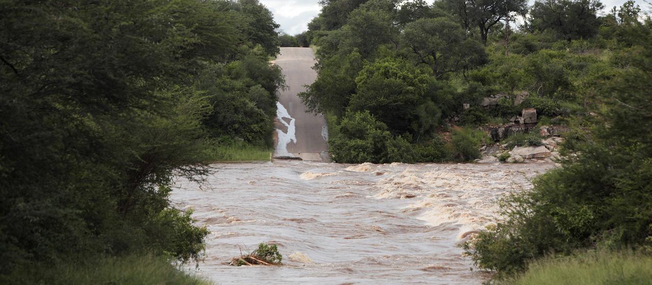 Eine überschwemmte Straße wurde von den Wassermassen beschädigt.