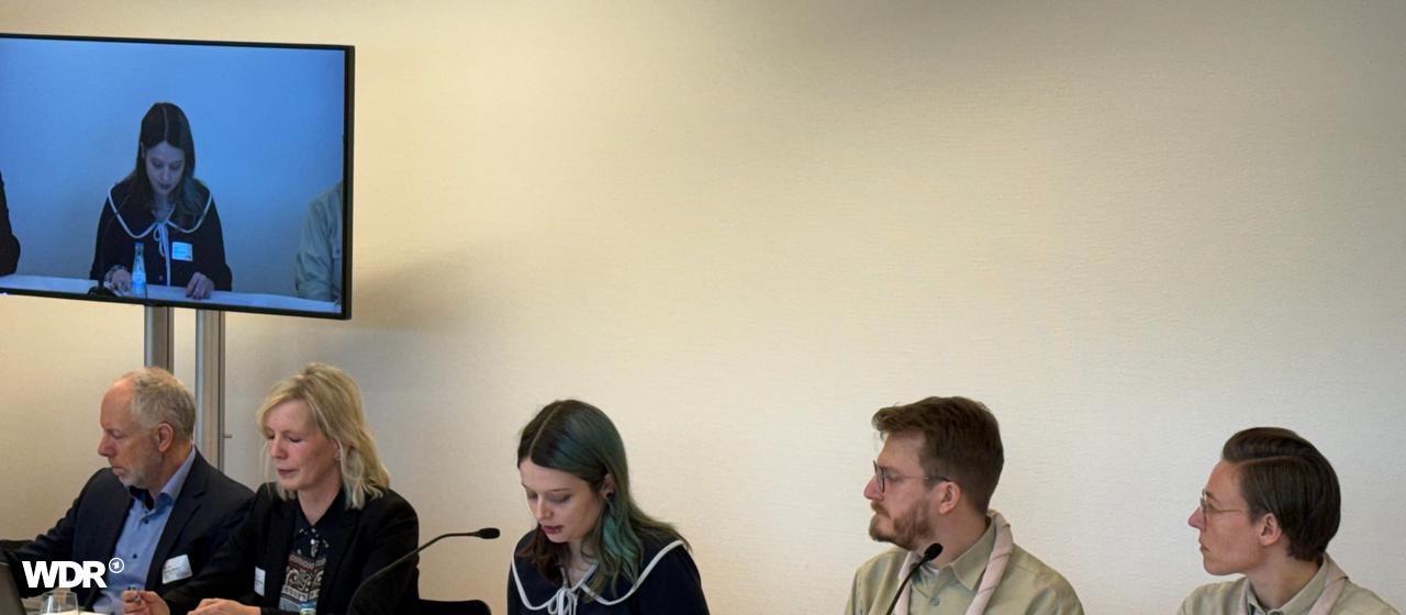 Auf dem Bild sieht man eine Pressekonferenz der Mönchengladbacher Pfadfinder. Insgesamt sitzen fünf Personen an einem Tisch. 