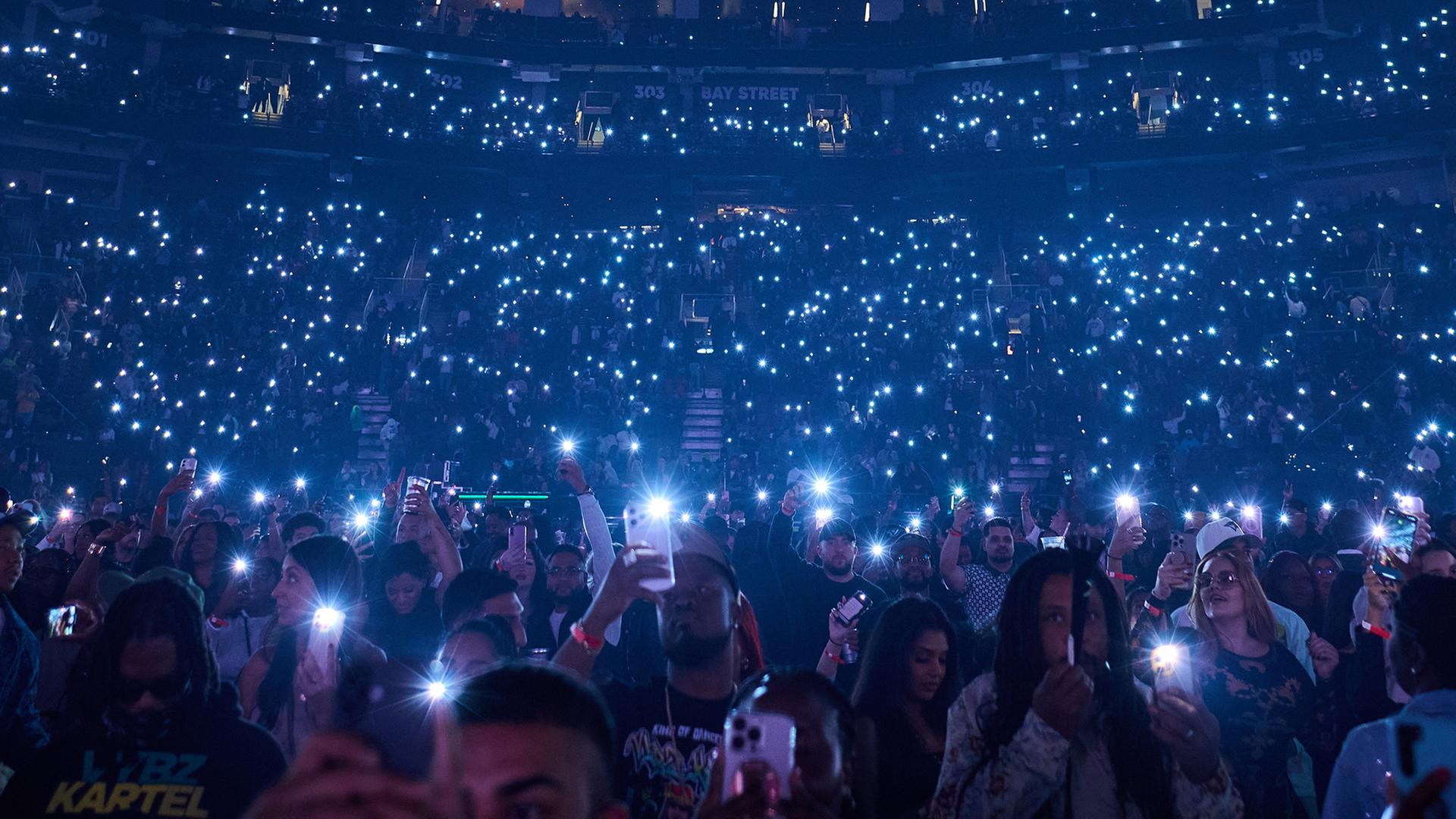 Fans schwenken die Taschenlampen ihrer Handys, bevor Vybz Kartel in der Scotiabank Arena in Toronto die B�hne betritt. | Sammy Kogan/The Canadian Press via AP