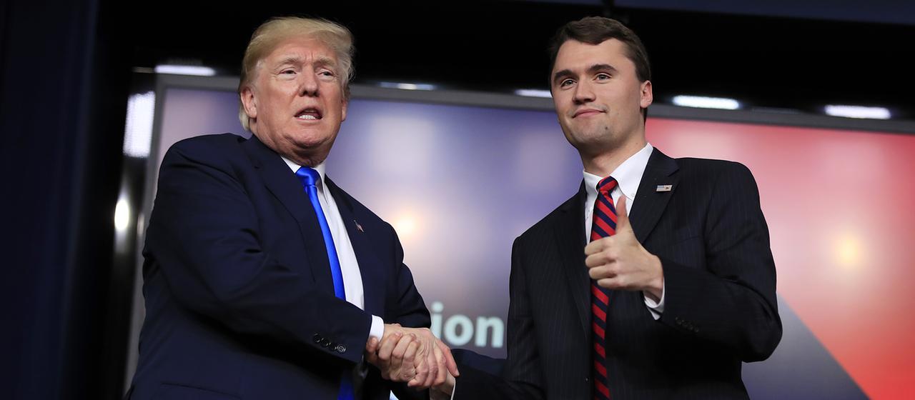 Donald Trump und Charlie Kirk geben sich auf einer Bühne die Hand. (Archivbild: 22.03.2018,)