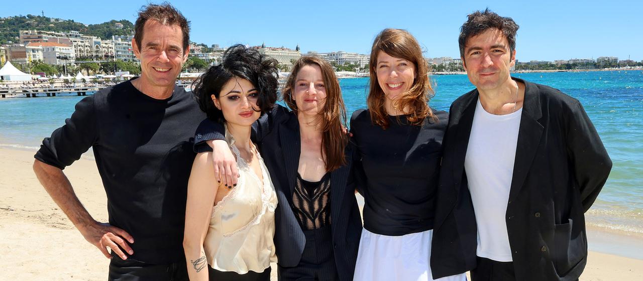 Die Filmschaffenden v.l.n.r. Tom Tykwer, Kurdwin Ayub, Helene Hegemann, Nora Fingscheidt, İlker Çatak am Strand von Cannes.